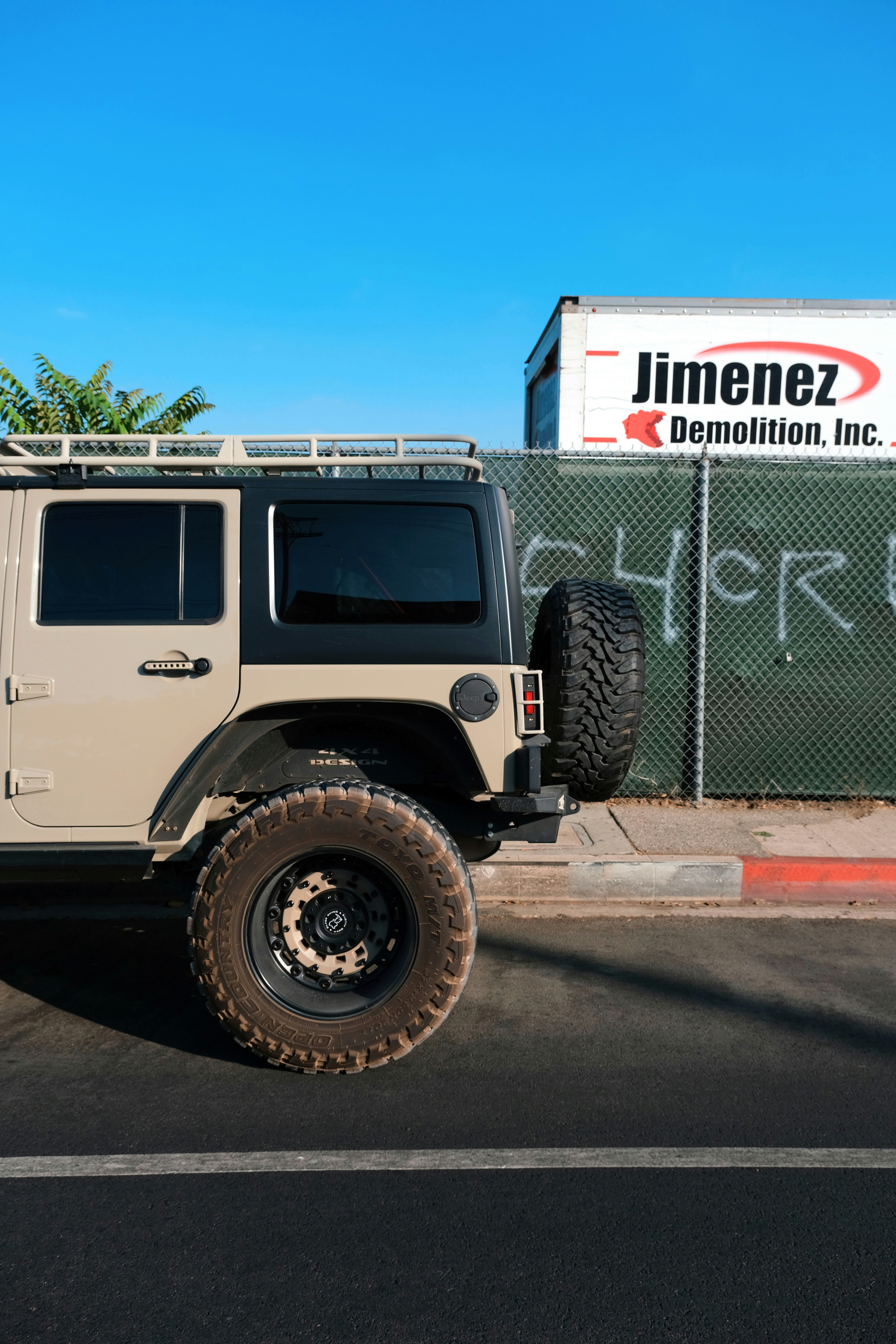 white and black jeep wrangler parked near gray metal fence during daytime